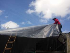 Putting the new plastic on the roof