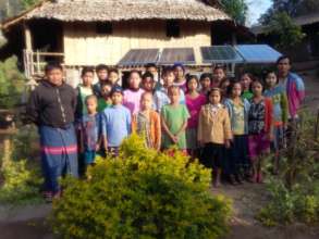 Students and teachers gathered around solar panels
