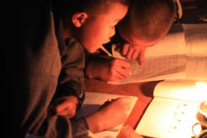Children studying by candlelight