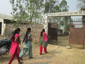 Girls on their way to school with the book in hand