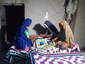 Women sewing relee work in night via solar bulb