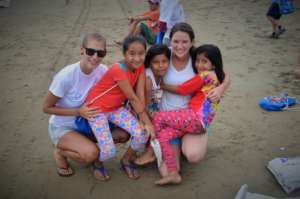 Volunteers with youth during beach clean up