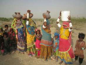 Women carrying water from the new water well.