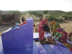 Women filling their water pitchers.