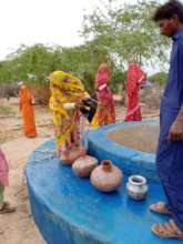 woman filling their pitchers with drinking water.
