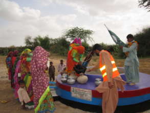Women in their traditional attire filling water.