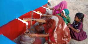 Women filling pitchers with sweet drinking water