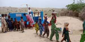 Girls happily taking water to their homes