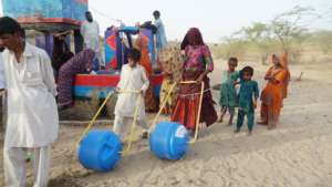 women & children are taking water in water wheelos