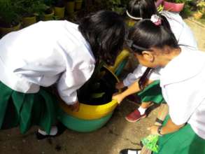 Little nurses empty stagnant water in playground