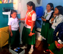 Tanjung Elementary mini-nurse helps weigh student