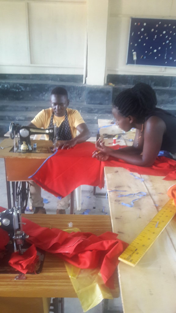 Clayan with his teacher making an Apron