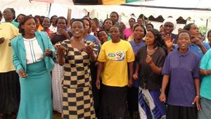 Olive Wolimbwa, WMI Manager,leads the borrowers in song