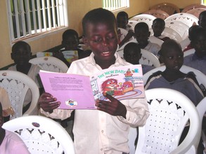 Buyohildren reading from the donated books in the new building.