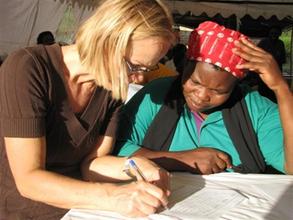 WMI Board Member, Trix Vandervossen, helps fill out loan forms