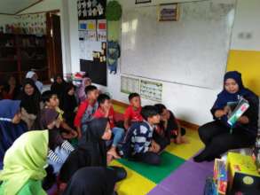 Miss Desy reading the book for the children