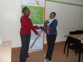 A staff handing over a pair of crutches