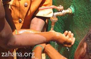 Children washing hands at a communal water faucet