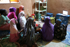 Girls crowd around laptop for documentary viewing