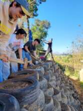 Volunteer group helps build tire retaining wall