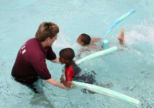 Coach Rob teaching swimming linking with a trust e