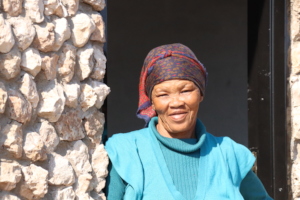 Lys standing in the doorway of her healing hut