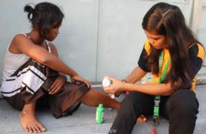 A junior health worker treats wounds of street kid