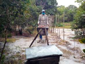 Beekeeper Eugene MOSA with his hive and cloth mask