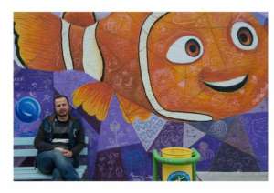 Ali with a community mural