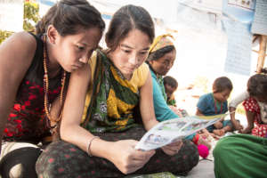 Two girls read an Outreach flyer on violence