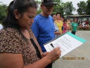 A community group leader signs the handover papers