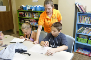 A Staff member is assisting with homework.