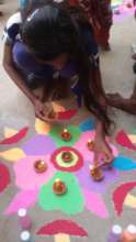 A young girl makes Rangoli at Diwali celebration