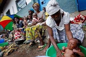 Woman washes newborn baby, Don Bosco Shelter, DRC