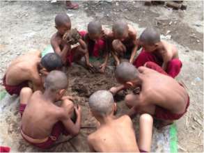 Young Buddhist monks learning natural building