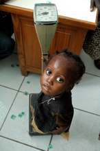 A malnourished child is weighed.
