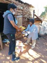 Thabo (one of our outreach nurses) hands over food