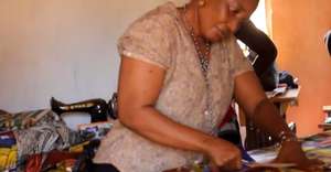 Mariama cuts fabric for dress