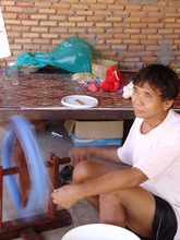 The husband of one of the spinners lends a helping hand.