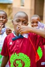 John enjoying a sachet water .