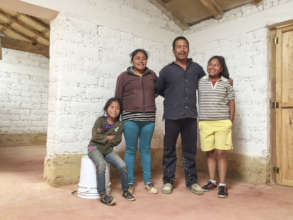 Family inside self-built reinforced adobe house