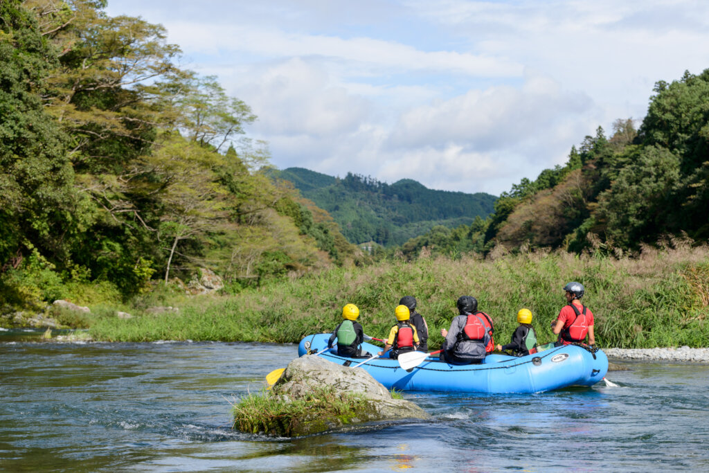 Kids rafting down a peaceful river in nature