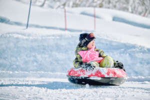Camper Enjoying Snow Tubing