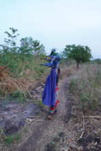 A woman carrying a pedal pump