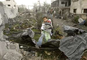 A Palestinian boy walks through the rubble