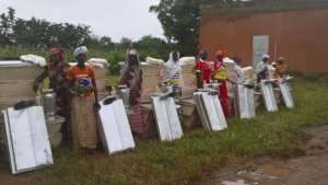 Women in front of their beekeeping equipment
