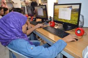 A girl explores the new computers at Azraq Camp