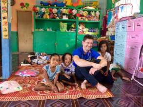 Trustee with children in Cambodian health centre