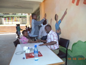 Some children getting check-up in the sun!