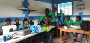 Youth group practices sewing at a community center